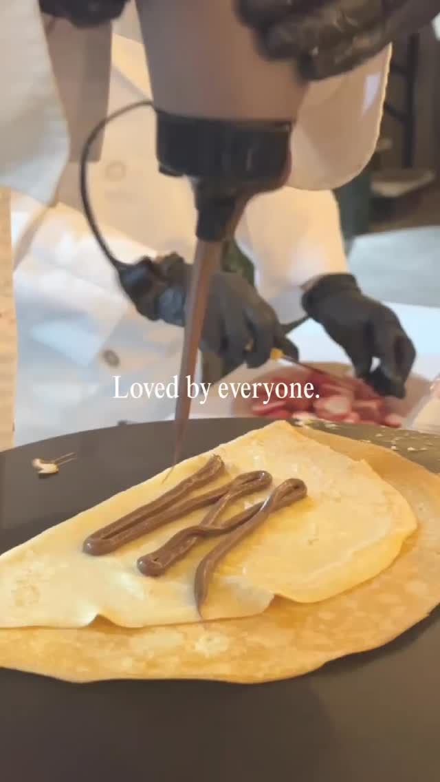 Crepe being poured with a gloved hand, close-up