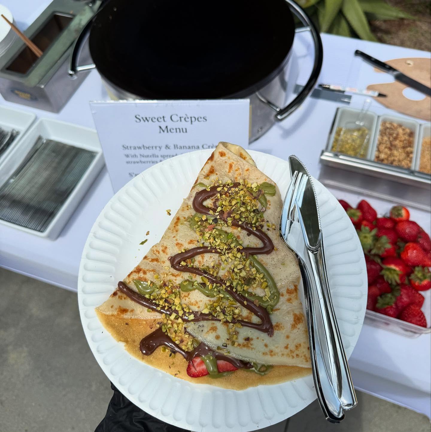 Happy guests at a Jannet Catering event, crepes in hand.